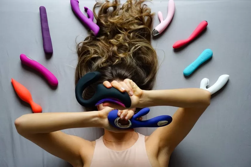 A woman displaying sex toys around her photo